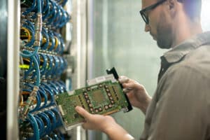 IT professional inspecting computer motherboard: types of managed services